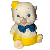 The Bitter Squeaks Yellow Bowtie Baby Elephant plush sits upright on a white background, featuring a yellow bowtie, yellow hat, and yellow pants.