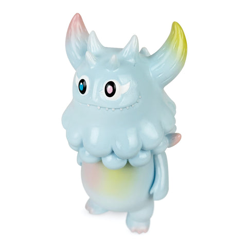 Rangeas Jr. — Light Blue by The Little Hut is a light blue, horned cartoon monster figurine with round eyes, fluffy texture, and pastel accents, standing on two legs against a white background.