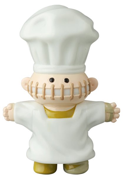 Medicom’s VAG 39 — Butcher is a Japanese vinyl toy figure dressed as a chef with a large white hat, stitched mouth design, and mismatched yellow and beige limbs from the Vinyl Artist Gacha series.