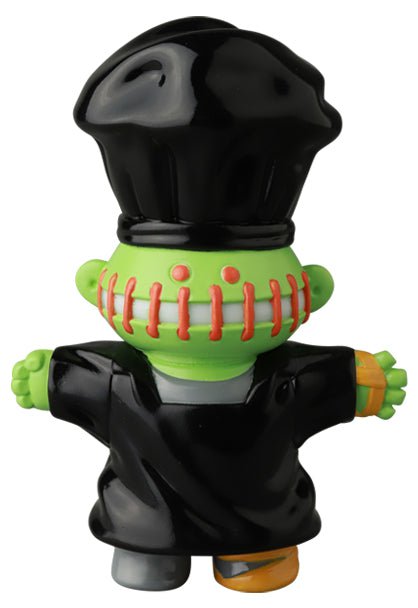 The Medicom VAG 39 — Butcher is a green Japanese vinyl toy with a black chef hat and outfit, red stitches on its mouth, and orange bandages on one foot—perfect for unique gachapon figure fans.