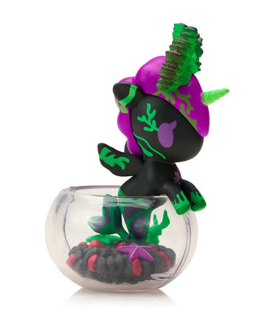 The tokidoki Neon Reef Mermicorno - Deep Star Coral Special Edition is a small unicorn figurine with purple and green details in a clear round container, featuring black and red elements plus glow-in-the-dark accents for extra charm.