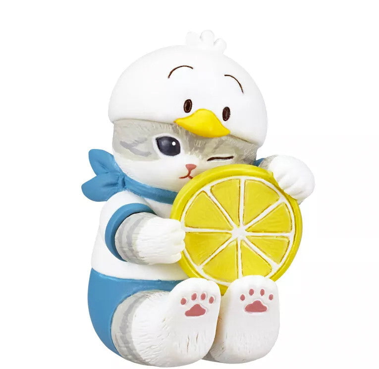 A Mofusand x Sanrio Series 2 Capsule figurine by Kitan Club features a winking kitty in a bird hat and blue costume, holding a yellow lemon slice against a white background.