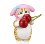 A small Mofusand x Sanrio Series 2 Capsule figurine by Kitan Club, featuring an orange and white cat in a pink hood with a blue bow, wearing a cute costume and holding two large red cherries.