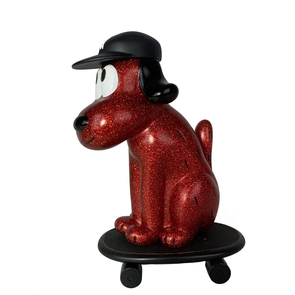 The How2Work One-Chu Sk8 - Red Glitter features a red glittery dog figure in a black cap, sitting on an 8-inch collectible red skateboard with wheels, shown against a white background.