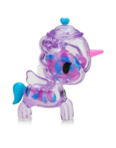 The tokidoki Sugar Shop Unicorno - Very Berry (Special Edition) is a transparent purple figure with blue and pink accents, heart-shaped lid, wings, and colorful beads inside—evoking sweet berry gummy rings.