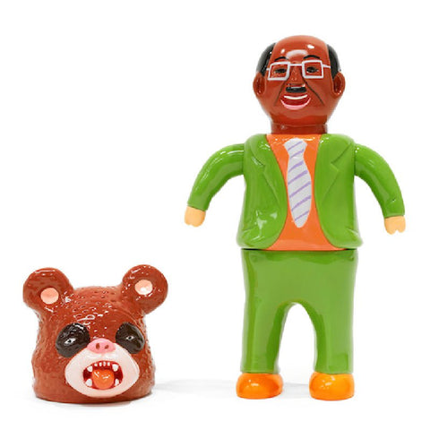 The Paradise Toy About Animals Satoshi Yamamoto—Panda 2nd features a toy figure in a green suit with an orange shirt and glasses, standing beside a removable bear mask with an open mouth showing teeth.