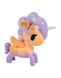 The Fortune Cookie Unicorno Blind Box by tokidoki features a small unicorn toy with a light orange body, lavender mane, tail, and wings, plus a silver horn. A surprise figure perfect for collectors! Displayed on a white background.