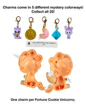 Five colorful charms and a slip of paper with a message are displayed above an open orange unicorn-shaped container. Each tokidoki Fortune Cookie Unicorno Blind Box contains one surprise figure and a special charm.