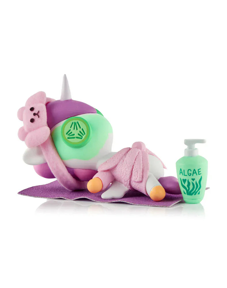The Spa Day Unicorno Blind Box by tokidoki features a pastel figurine on a purple mat with a towel, bear mask, and 