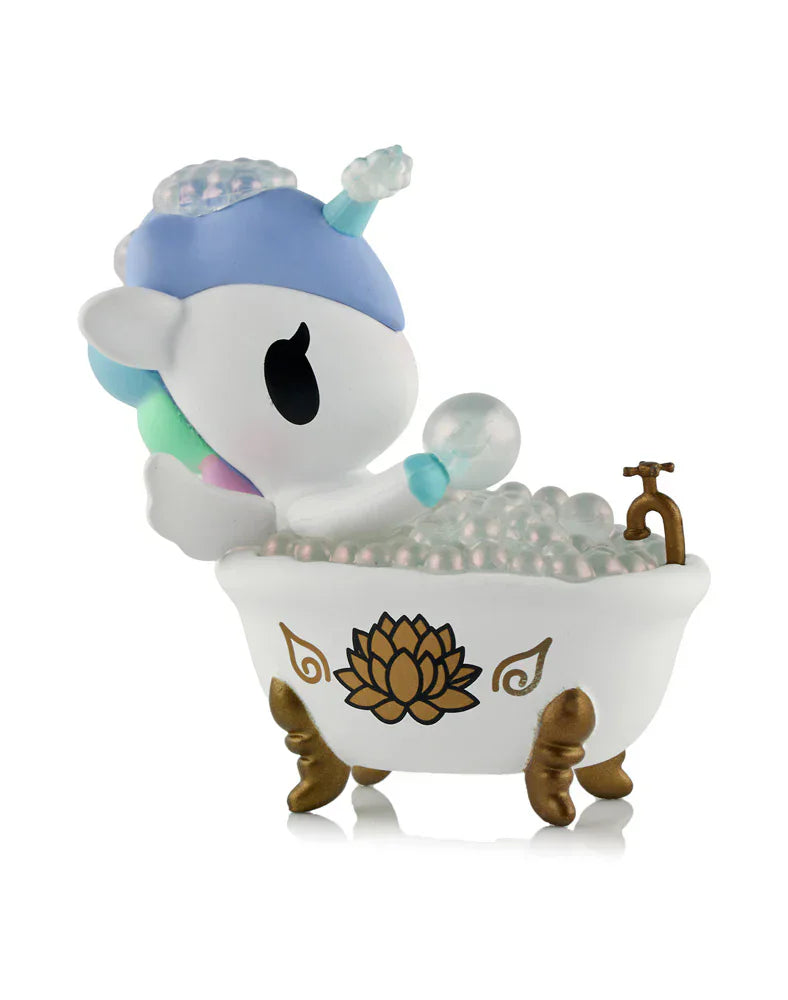 The tokidoki Spa Day Unicorno Blind Box features a pastel Unicorno relaxing in a white clawfoot tub with gold accents and bubbles, creating an adorable kawaii wellness scene.