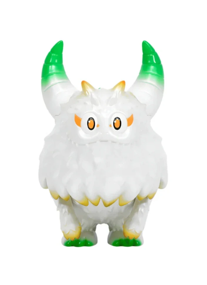 The Little Hut’s Rangeas Rex Jr. — White & Gold is a fluffy collectible toy with two green-tipped horns, orange eyebrows, yellow claws, and wide eyes, shown standing against a plain background.