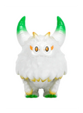 The Little Hut’s Rangeas Rex Jr. — White & Gold is a fluffy collectible toy with two green-tipped horns, orange eyebrows, yellow claws, and wide eyes, shown standing against a plain background.