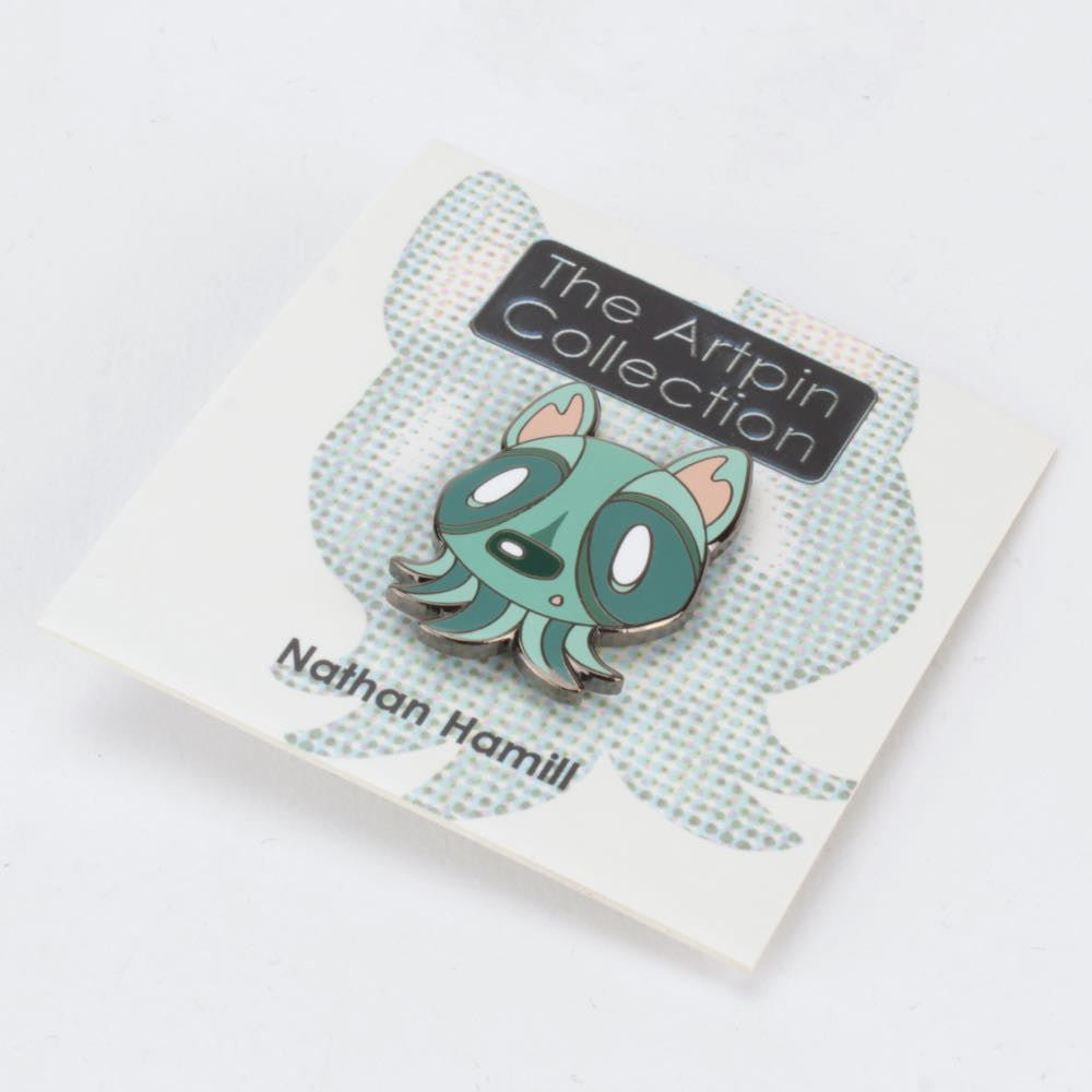 A limited edition enamel pin from The Artpin Collection – Octopup features a cartoon-style green creature with big eyes and small ears, mounted on a branded card by The Artpin Collection.