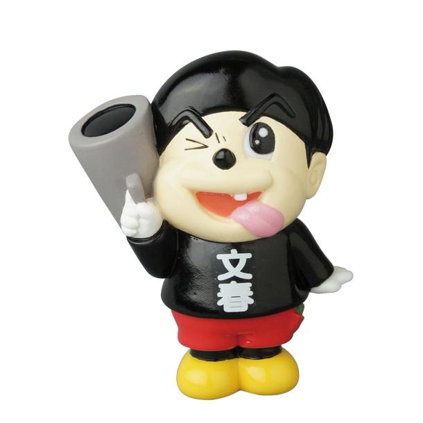 The Vinyl Artist Gacha Series 13 - Fumharu Kun by Medicom is a cartoonish figurine with a black hat, black shirt with white characters, red pants, yellow shoes, winking and sticking out its tongue while holding a large gray object over its shoulder.