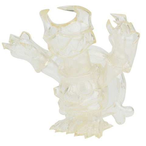 The One-Up Skuttle-X All Clear is a clear turtle figurine with raised arms, sharp teeth, claws, and a horned helmet on a round base, showcasing unique turtle style.