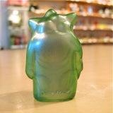 The Pop Soda Popsoda Finger Puppet - Clear Green is a small, translucent green figurine displayed on a smooth surface in soft indoor light, shown facing away from the camera.