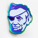 The Rotofugi Pirate Abe Enamel Pin by Rotofugi features Abraham Lincoln’s face with an eye patch and a blue-green gradient outline—a colorful accessory from the designer toy store.