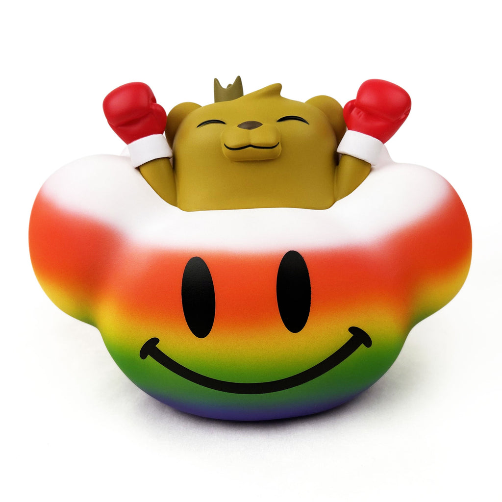 A brown bear with a crown and red boxing gloves, inspired by JC Rivera's Bear Champ, sits in a rainbow object with a big black smiley face—In My Happy Place — Rainbow by Strangecat Toys, a Rotofugi exclusive lamp.