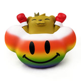 A brown bear with a crown and red boxing gloves, inspired by JC Rivera's Bear Champ, sits in a rainbow object with a big black smiley face—In My Happy Place — Rainbow by Strangecat Toys, a Rotofugi exclusive lamp.